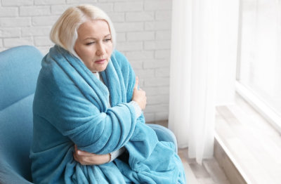 woman wrapped in blanket suffering from cold
