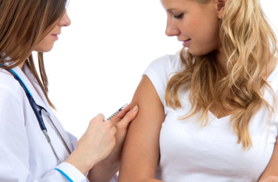 doctor having arm injection to a young woman